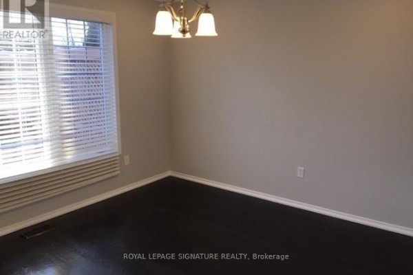 Interior dining room with dark hardwood floors, grey walls, and a window. - Upper - 7092 Walworth Court, Mississauga