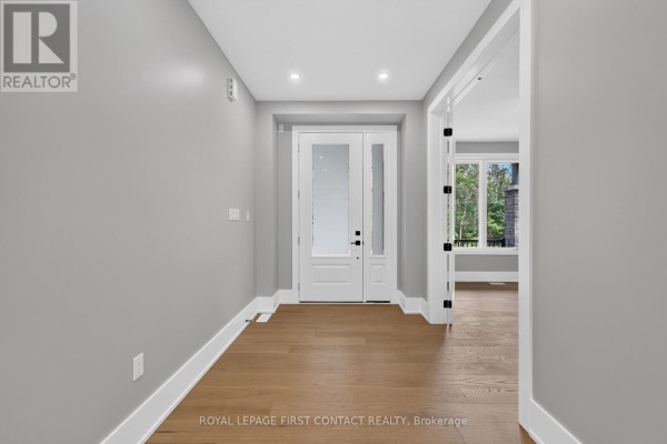 Empty home entryway with light grey walls, white trim, and hardwood floors. - Upper - 929 7th Line, Innisfil