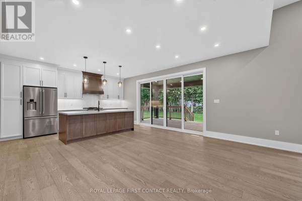 Open concept living area with a kitchen, island, and patio doors to the backyard. - Upper - 933 7th Line, Innisfil
