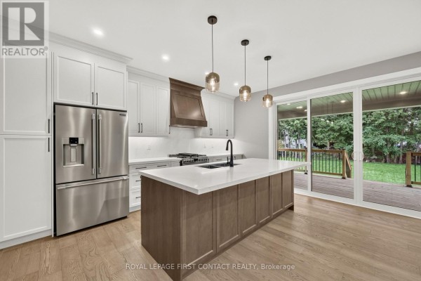 Kitchen with white cabinets, wood island, stainless steel appliances, and quartz countertops. - Upper - 933 7th Line, Innisfil