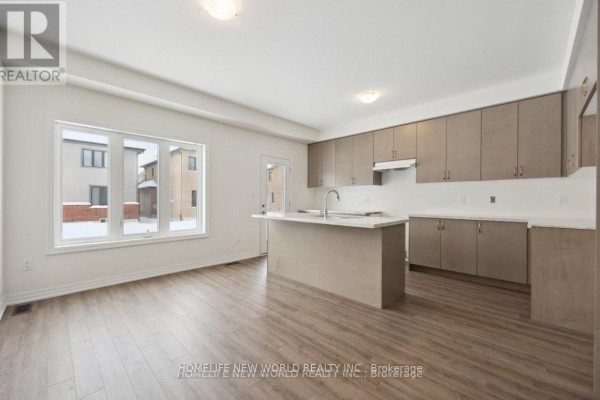 Modern kitchen with light wood cabinets, a large island, and a dining area. - Detached 4 Bedrooms House - 10 Ken Davie Gate, Georgina