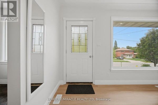 Interior view of the entrance area with white walls, a white door with glass panes, and a large window. - Upper Level - 199 Allen Street E, Waterloo