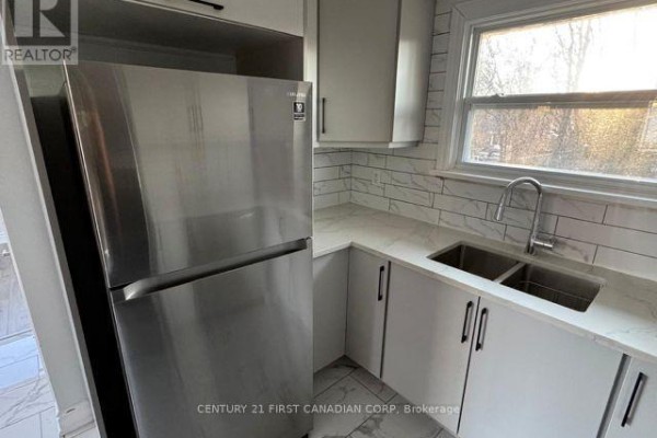 Kitchen with stainless steel refrigerator, white cabinets, and marble backsplash. - Upper Level - 31 Thorncrest Crescent, London South