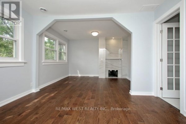 Living room with light blue walls, hardwood floors, and a marble fireplace. - Upper Level - 420 Annette Street, Toronto