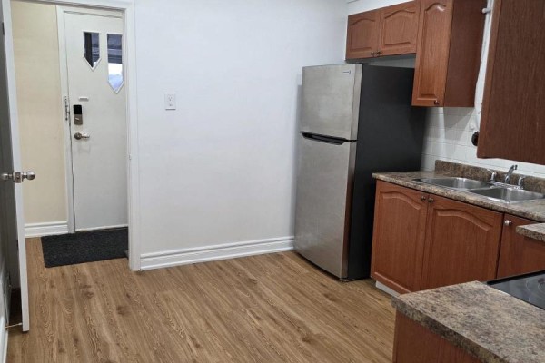 An open white linen closet with three shelves is next to a bathroom with a glass shower. - Upper Only - 478 Brimley Road, Toronto