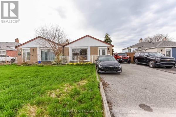 Front elevation of a beige brick house with a white railing and green lawn. - Upper Portion - 137 Avondale Boulevard, Brampton