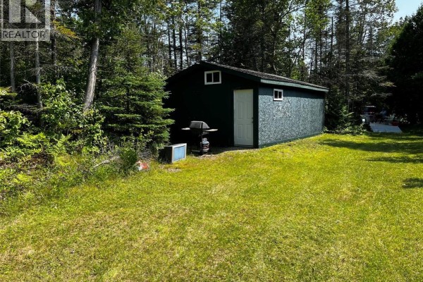 View of green shed with a white door, barbecue, and a small blue bin outside. - V/l Warner Bay Road, Bruce County