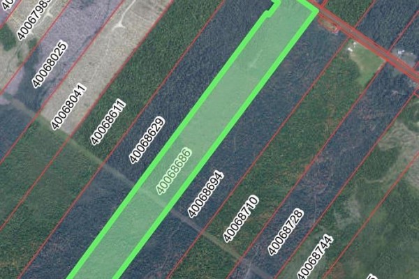 Aerial view of a vacant lot highlighted in green, showing property lines and surrounding wooded areas. - Vacant Lot Route 11, Redmondville