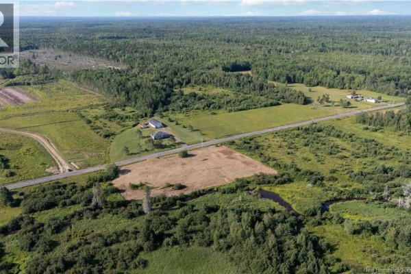 Aerial view of a road passing through a rural landscape with houses, fields, and forests. - Vacant Lot Saint-charles Sud, Saint Charles