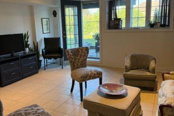Basement recreation room with French doors to the backyard, tiled floor, and seating arrangement. - W/o Basement - 21 Bristlewood Crescent, Vaughan