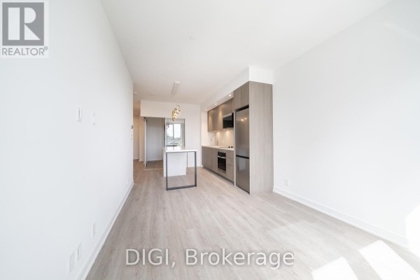 View of modern kitchen and dining area from the entrance hallway. - W320 - 485 Perth Avenue, Toronto