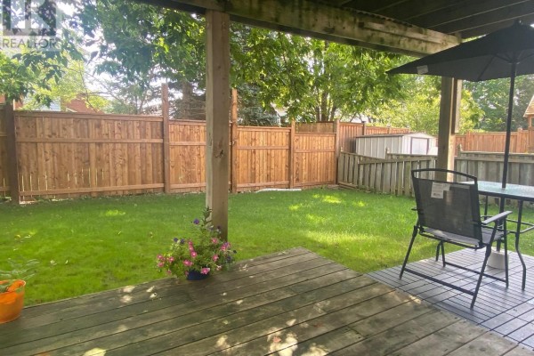 Exercise bike in front of French doors with view of backyard deck. - Walkout Basement - 46 Tradewinds Place, Kitchener