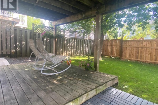 Corner kitchen with white and wood cabinets, stainless steel appliances, and dining table. - Walkout Basement - 46 Tradewinds Place, Kitchener