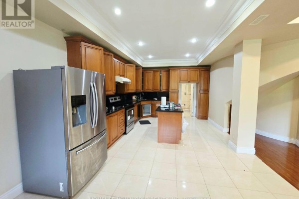 Basement kitchen with stainless steel refrigerator, dark wood cabinets, and tiled floor. - Walkout Bsm - 122 Centennial Road, Toronto