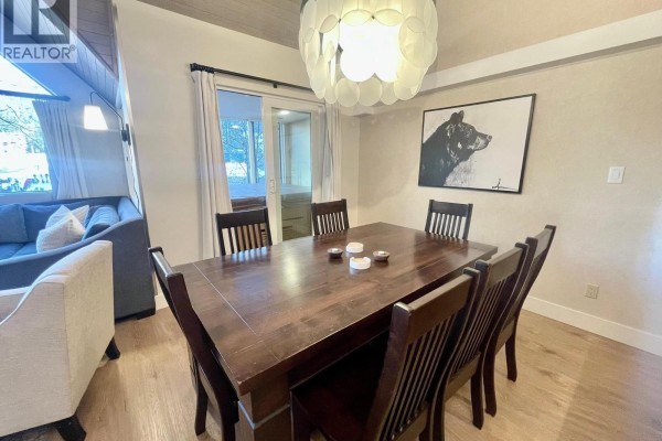 Dining room with wooden table, decorative lighting, and artwork on the wall. - Week 9 902-4293 Mountain Square, Whistler