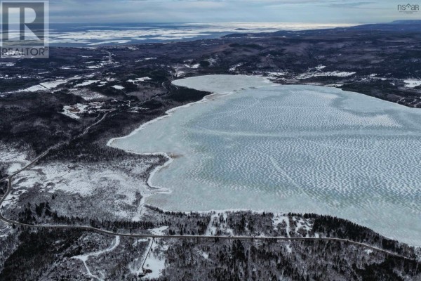 Aerial perspective of Lake Ainslie and surrounding landscape, showing icy water and forested areas. - West Lake Ainslie Road, Lake Ainslie