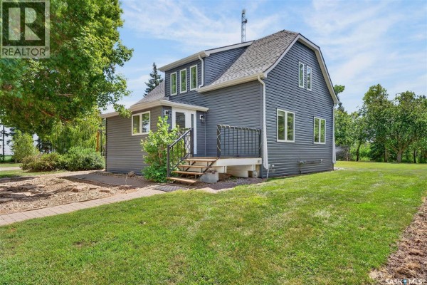 Side view of a dark blue house with a small deck and stairs. - Williams Acreage, Wolverine Rm No  340