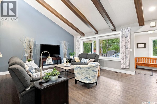 Living room with vaulted ceilings, exposed wooden beams, gray walls, and a seating area. - Zehner,rm Edenwold No 158 -fabian Acreage,80 Acres, Edenwold Rm No 158